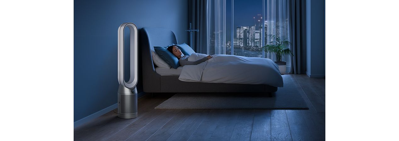 Dyson purifier in a dark bedroom with someone sleeping peacefully 
