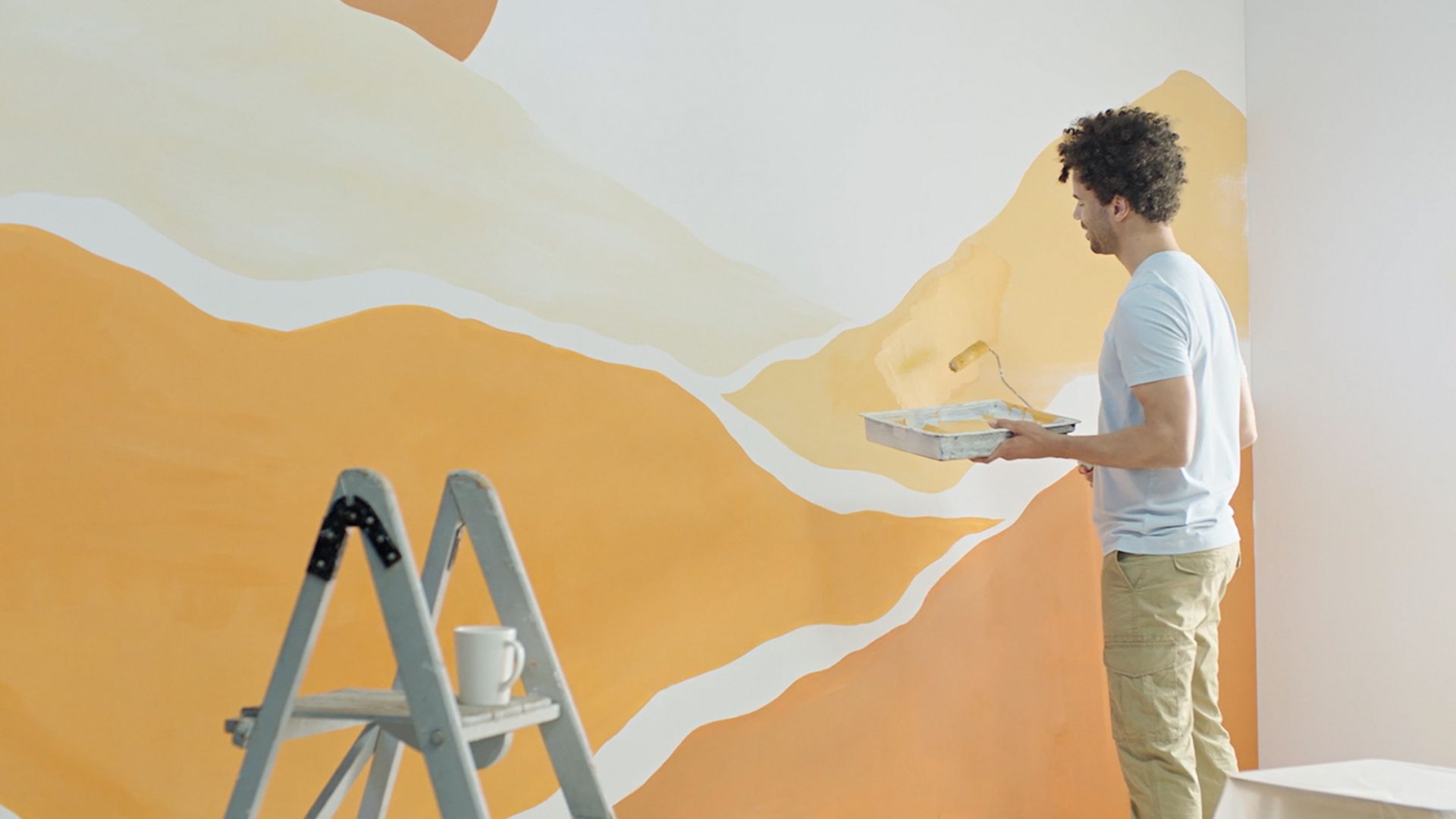 Ein Mann streicht eine innenliegende Wand. Ein Mann streicht eine innenliegende Wand.
