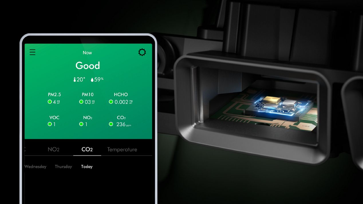 Close-up of the CO₂ sensor, with a smartphone screen showing levels of CO₂ and pollutants in the home.