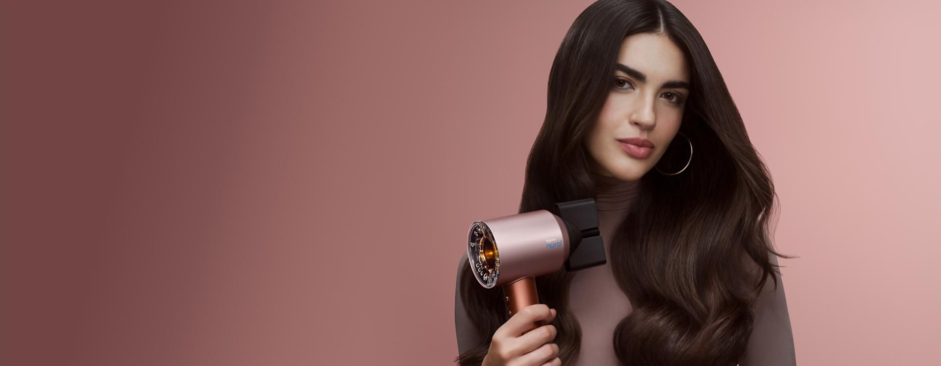 Uscătorul de păr Dyson Supersonic Nural folosit de un model pentru a-și usca părul.