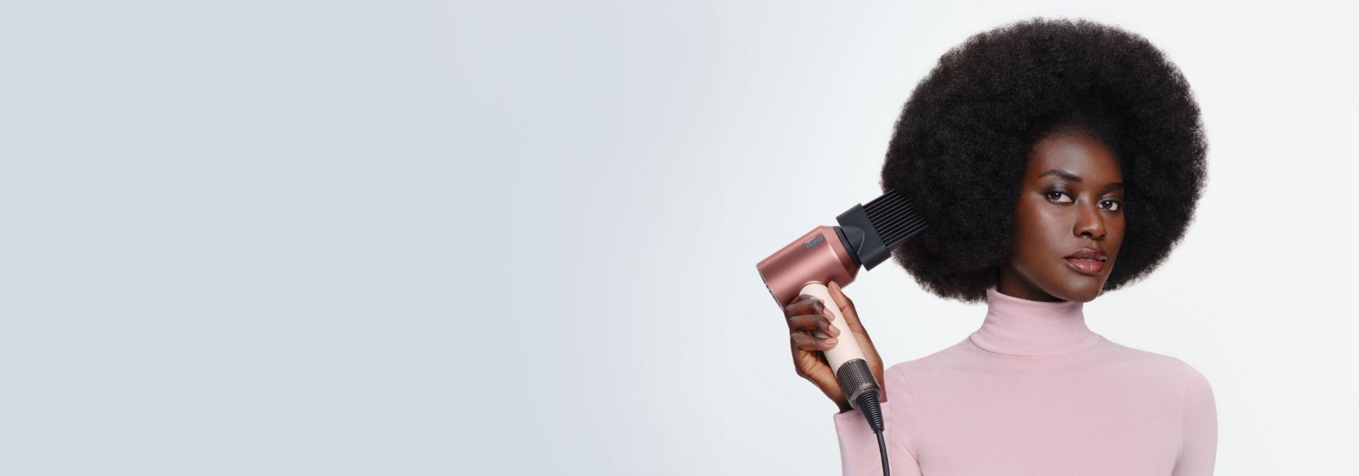 Model curls her hair using the Dyson Airwrap i.d. multi-styler and dryer.