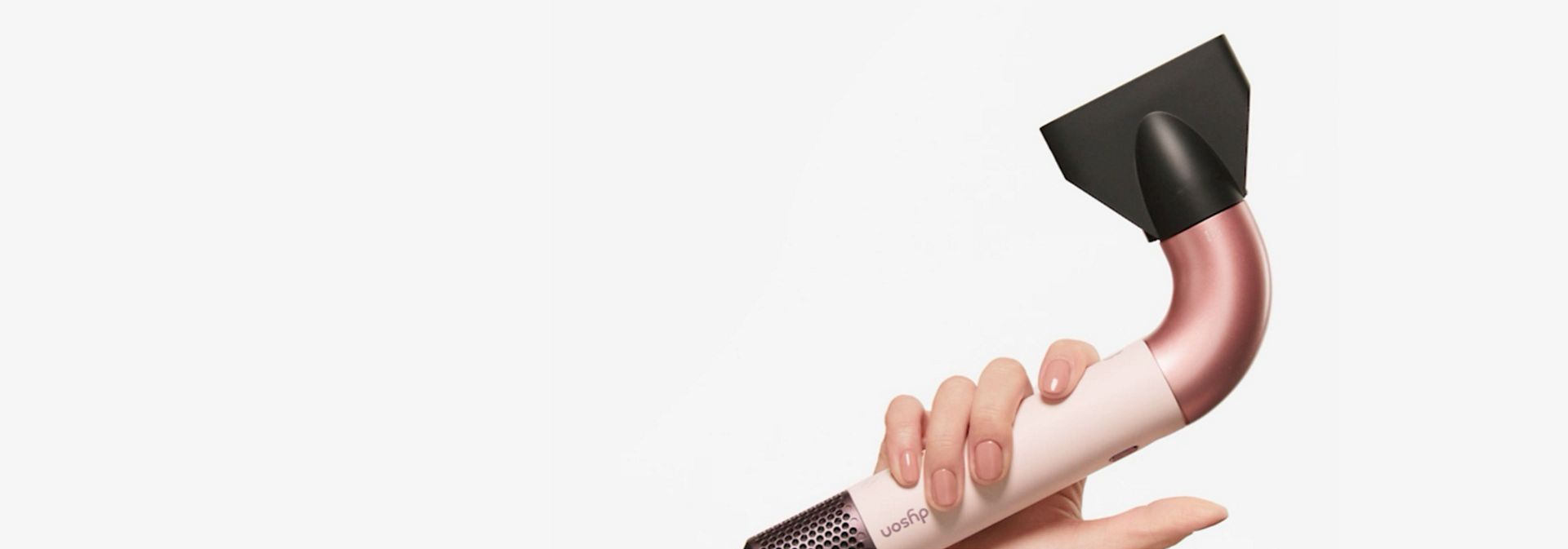 The Dyson Supersonic r hair dryer with the Gentle air attachment held by a model.