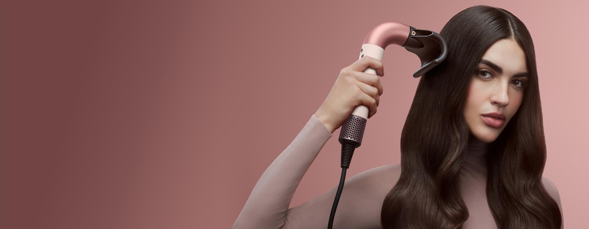 Dyson Supersonic r hair dryer used by a model to dry her hair.