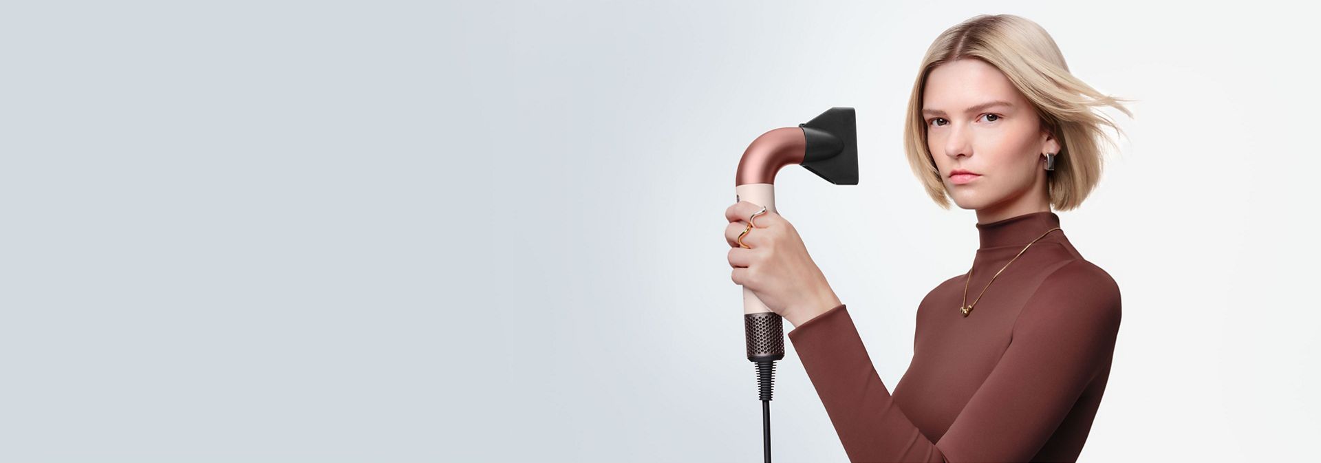 Model dries her hair with the Dyson Supersonic Nural hair dryer.