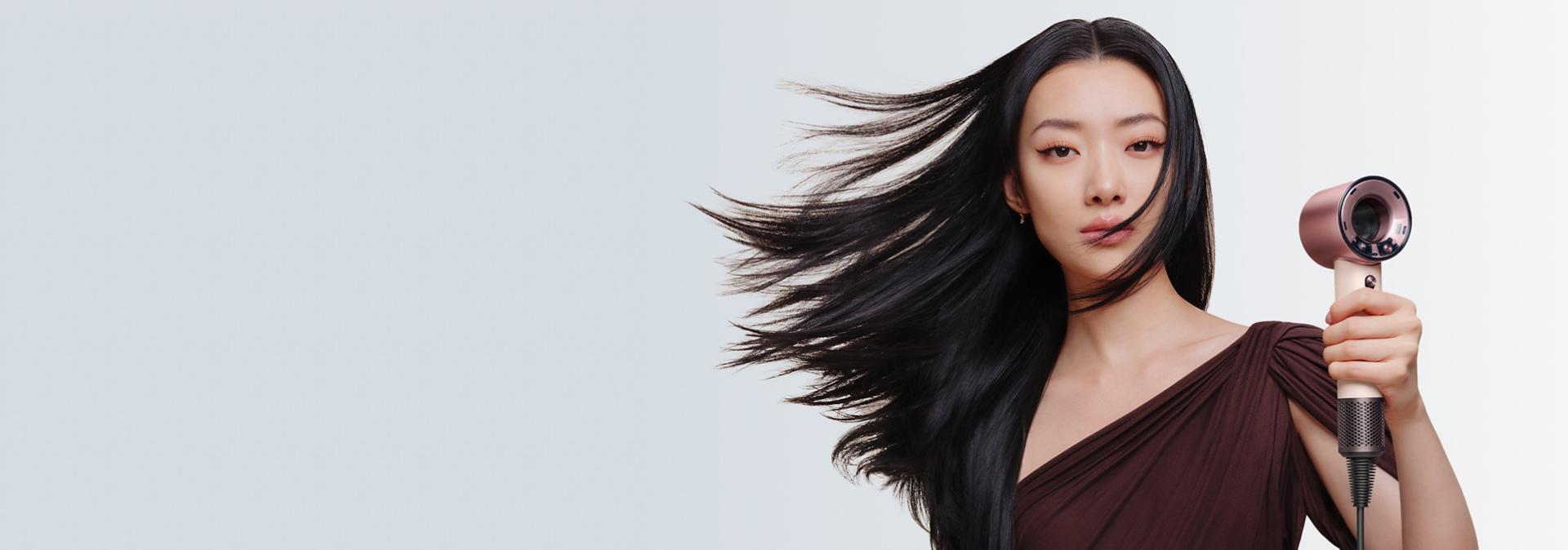 Model with smooth, styled hair after using the Dyson Supersonic Travel hair dryer.