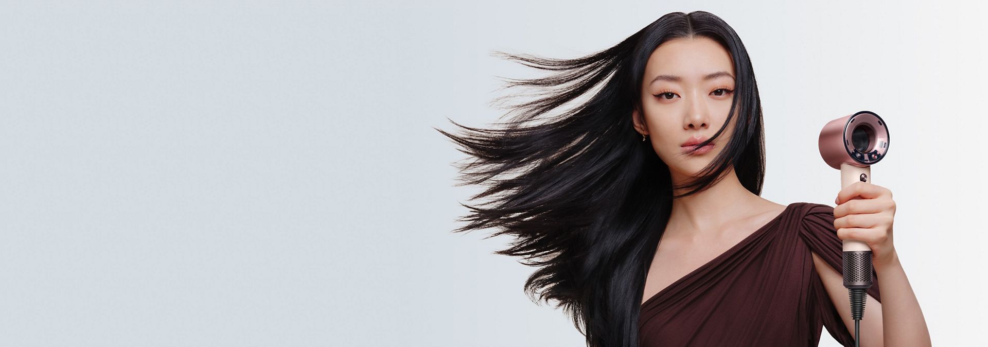 Model with smooth, styled hair after using the Dyson Supersonic Travel hair dryer.