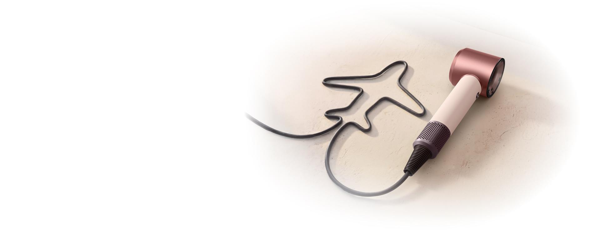 Dyson Supersonic Travel hair dryer with the cable shaped to resemble an aeroplane.