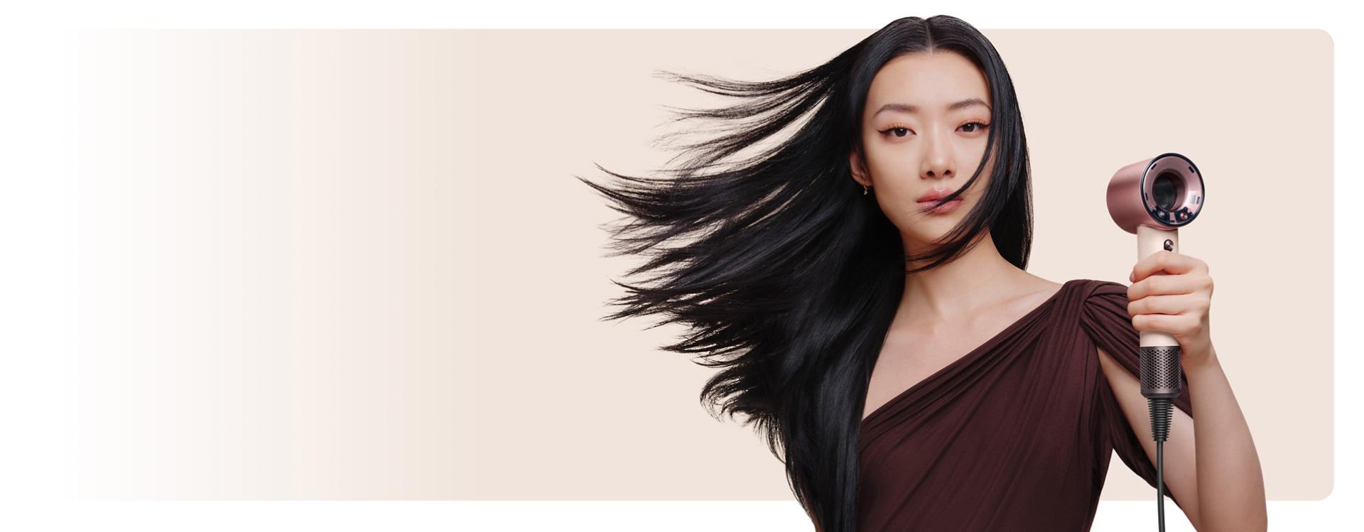 Model with smooth, styled hair after using the Dyson Supersonic Travel hair dryer.