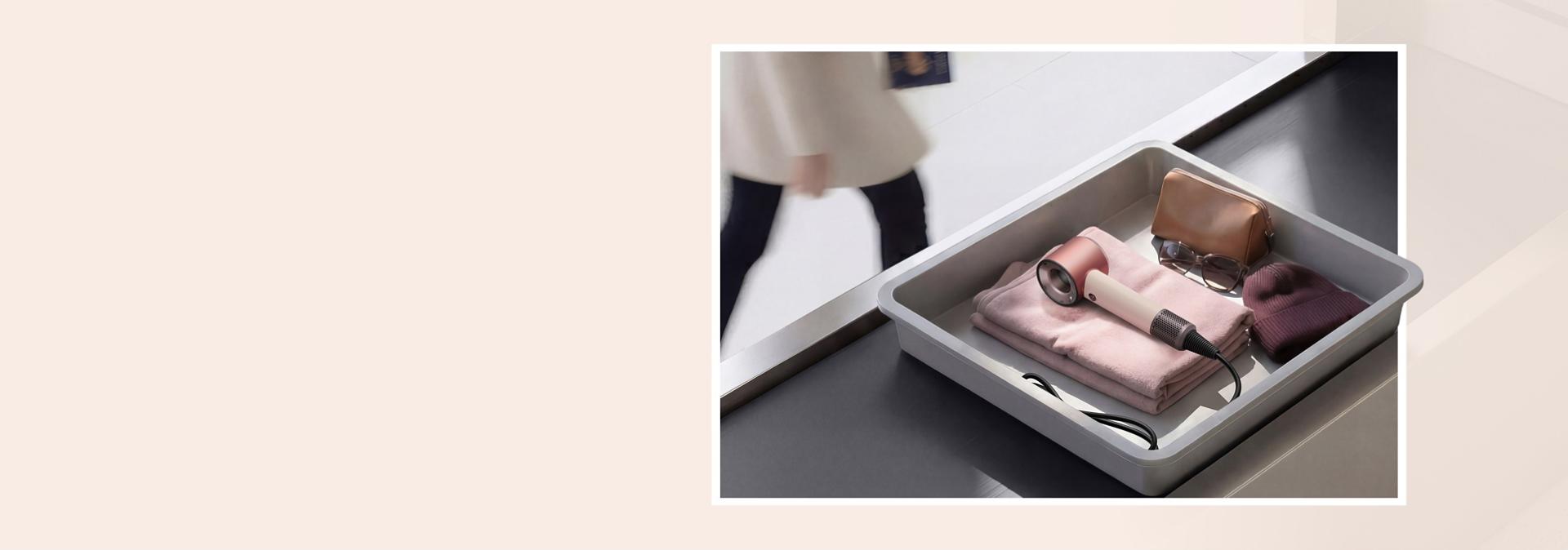 Dyson Supersonic Travel hair dryer in an Airport luggage screening tray.