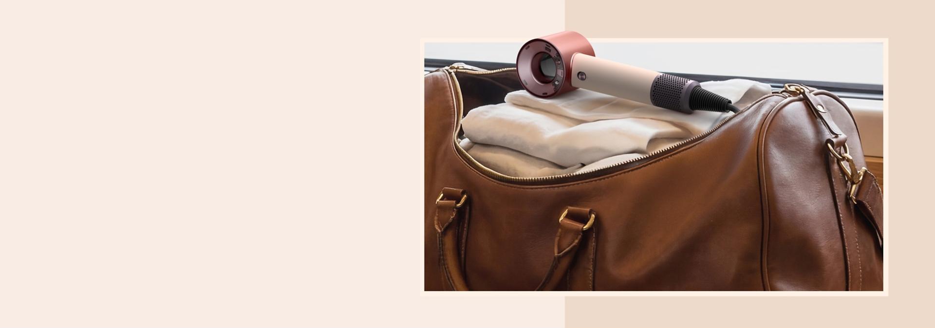 Dyson Supersonic Travel hair dryer in a leather travel bag.