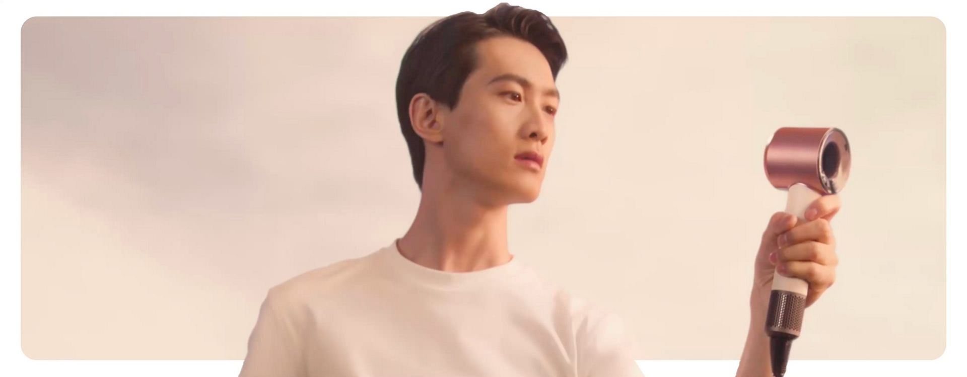 Model holds the Dyson Supersonic Travel hair dryer in front of them.