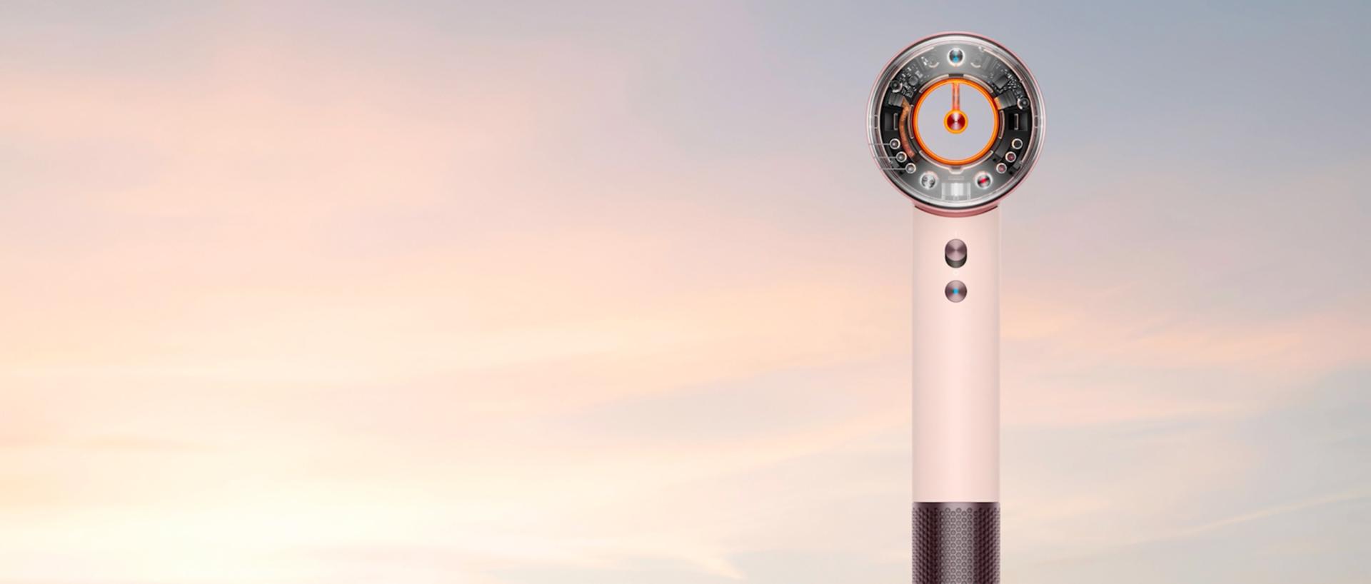 Dyson Supersonic Travel hair dryer in front of a sunrise.