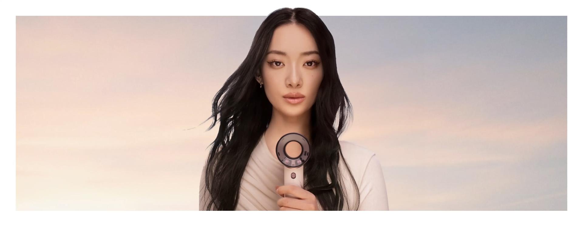 Modell hoiab enda ees fööni Dyson Supersonic Travel.