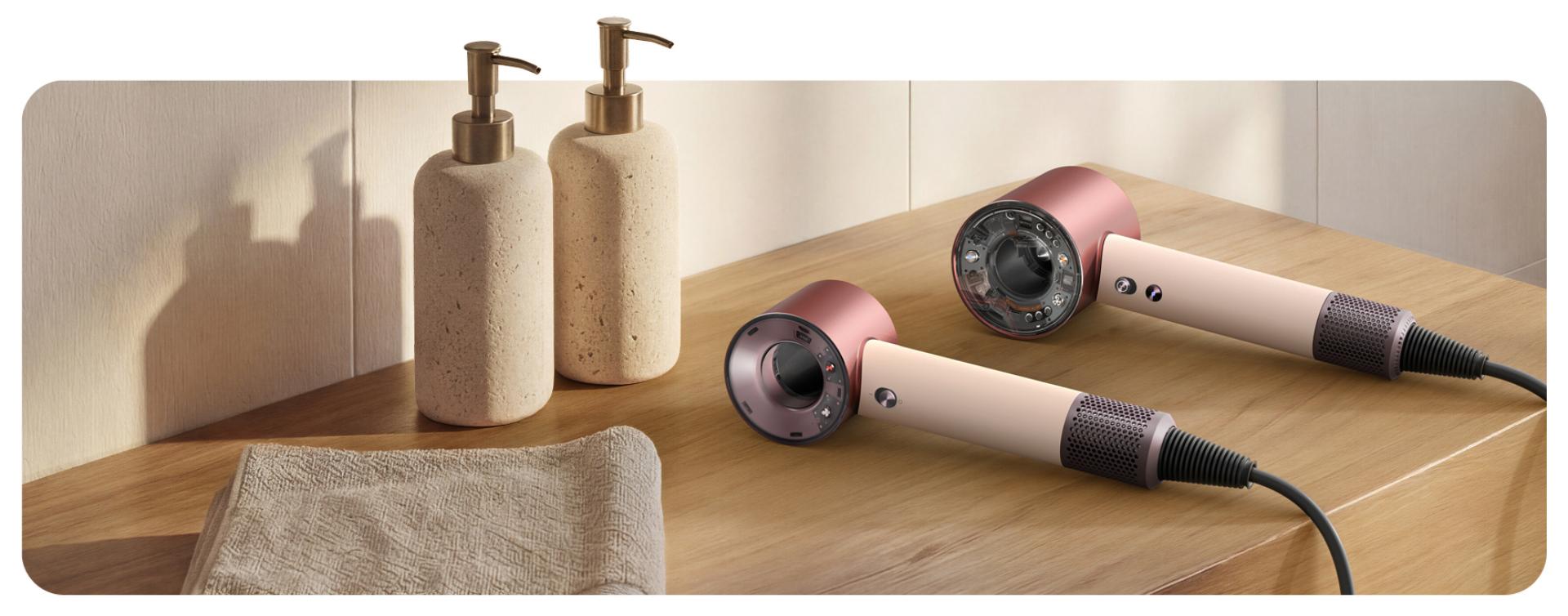 Dyson Supersonic Travel and Nural hair dryers on a bathroom shelf.