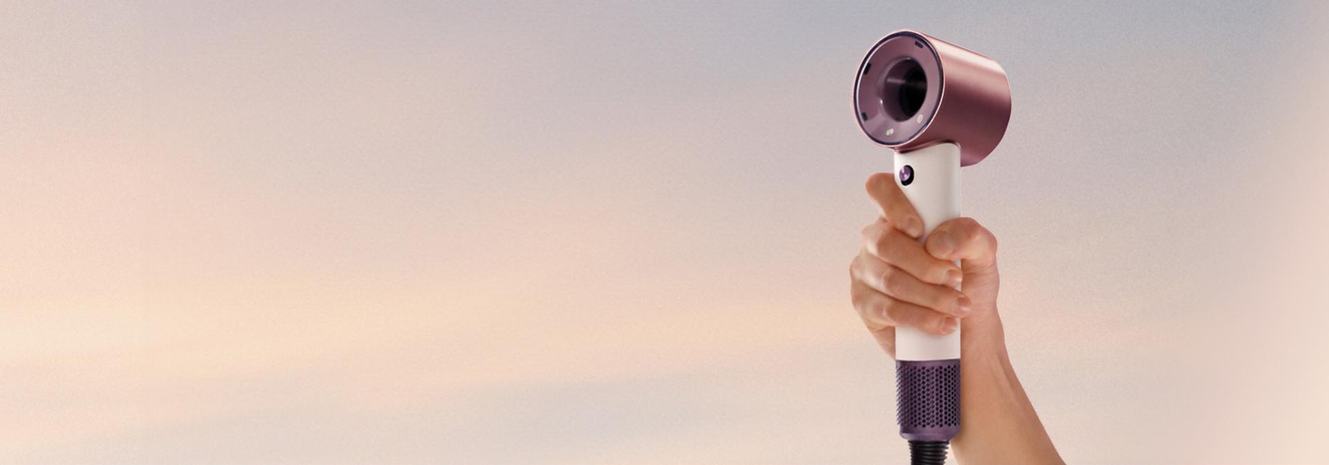 Dyson Supersonic Travel hair dryer held in a hand.