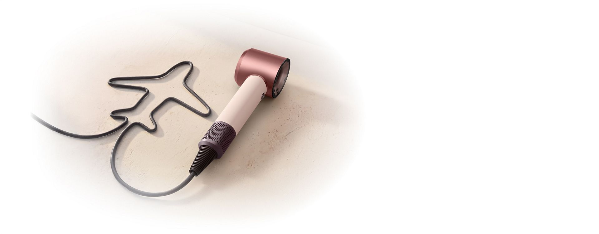 Dyson Supersonic Travel hair dryer with the cable shaped to resemble an aeroplane.