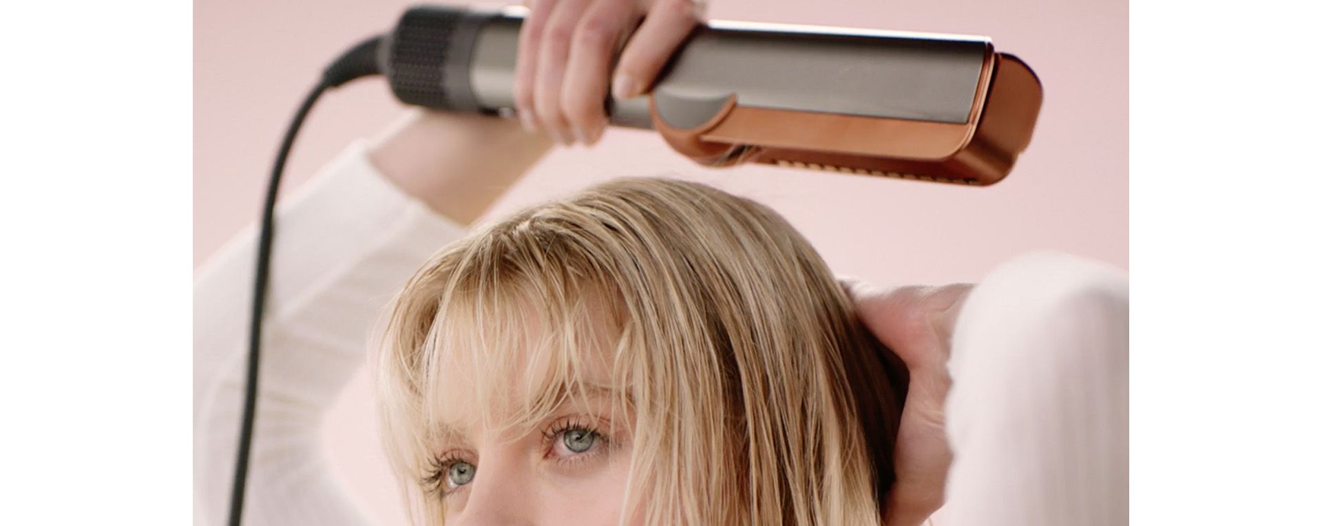A model uses the Dyson Airstrait straightener to pre-dry the roots of her hair.