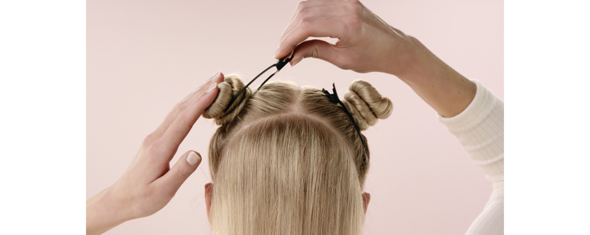 A model sections her hair with Dyson sectioning hair clips.