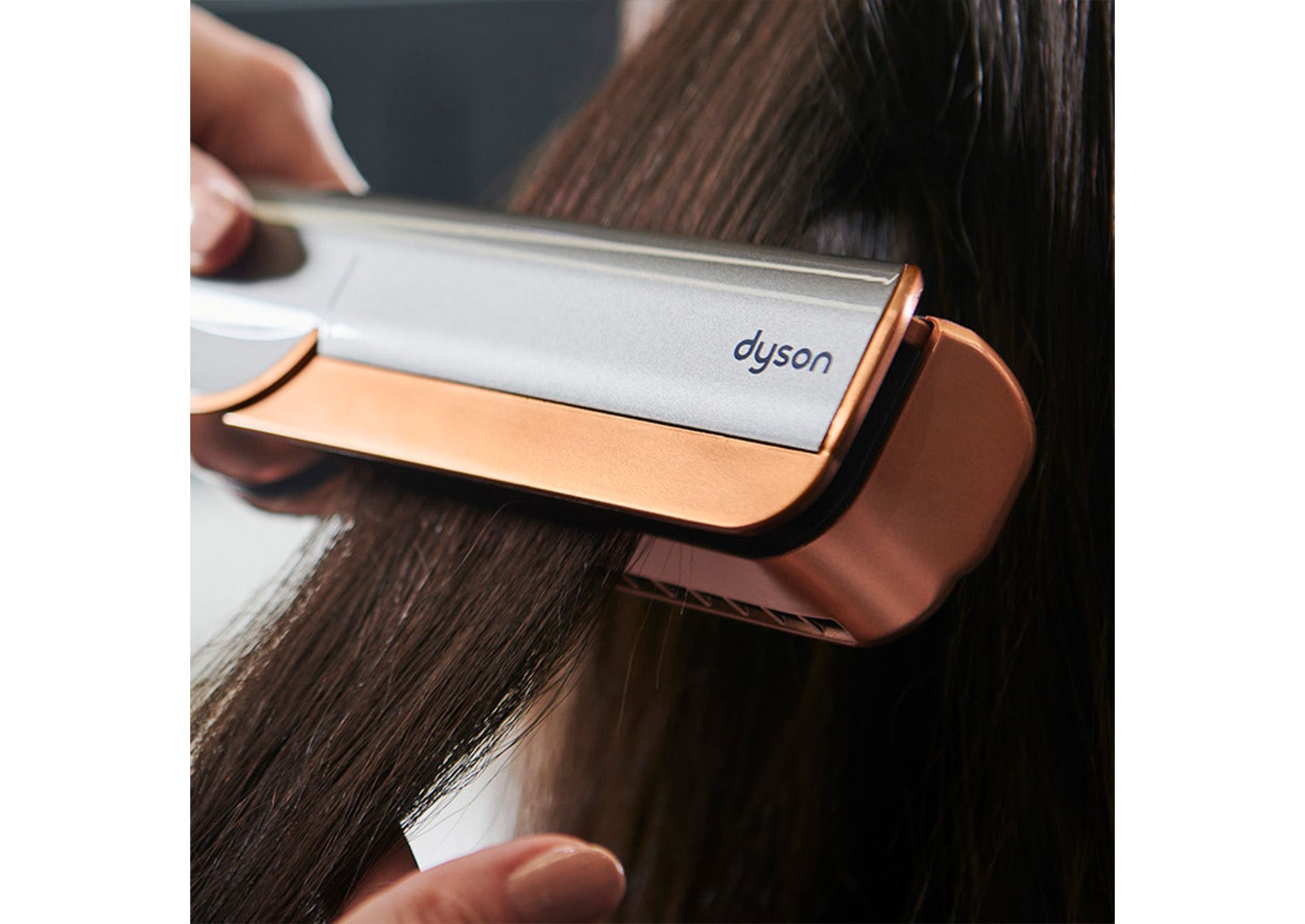 A Dyson Airstrait straightener is used to style a model’s hair.