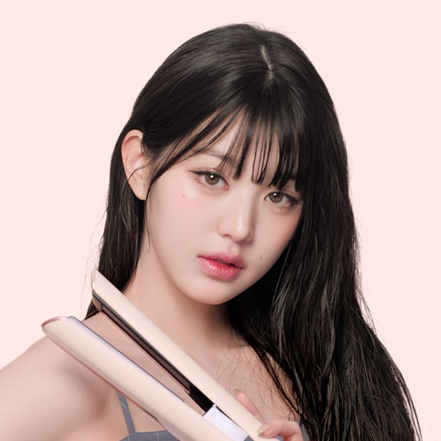 Model dries and straightens her hair with the Dyson Airstrait dryer and straightener.