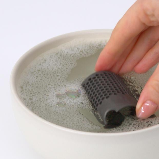 The filter of the Dyson Airstrait dryer and straightener is soaked in a bowl of water.