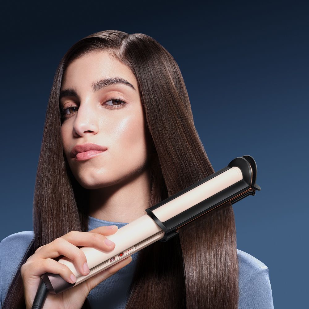 Model using the Dyson Corrale CoolShine hair straightener.