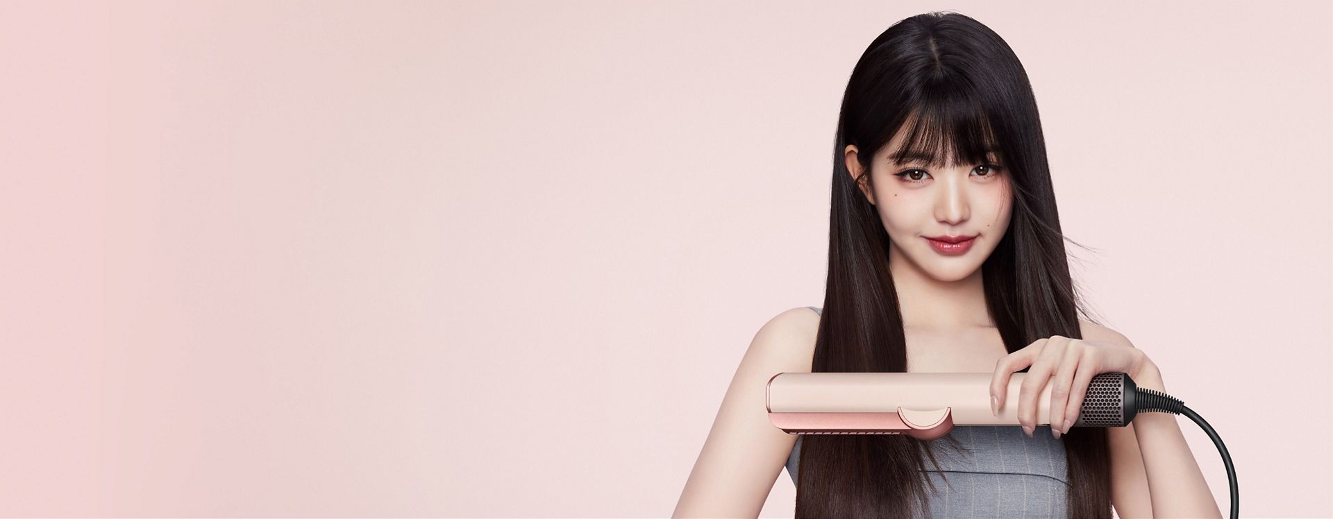 Jang Won-young straightens her hair with the Dyson Airstrait dryer and straightener.