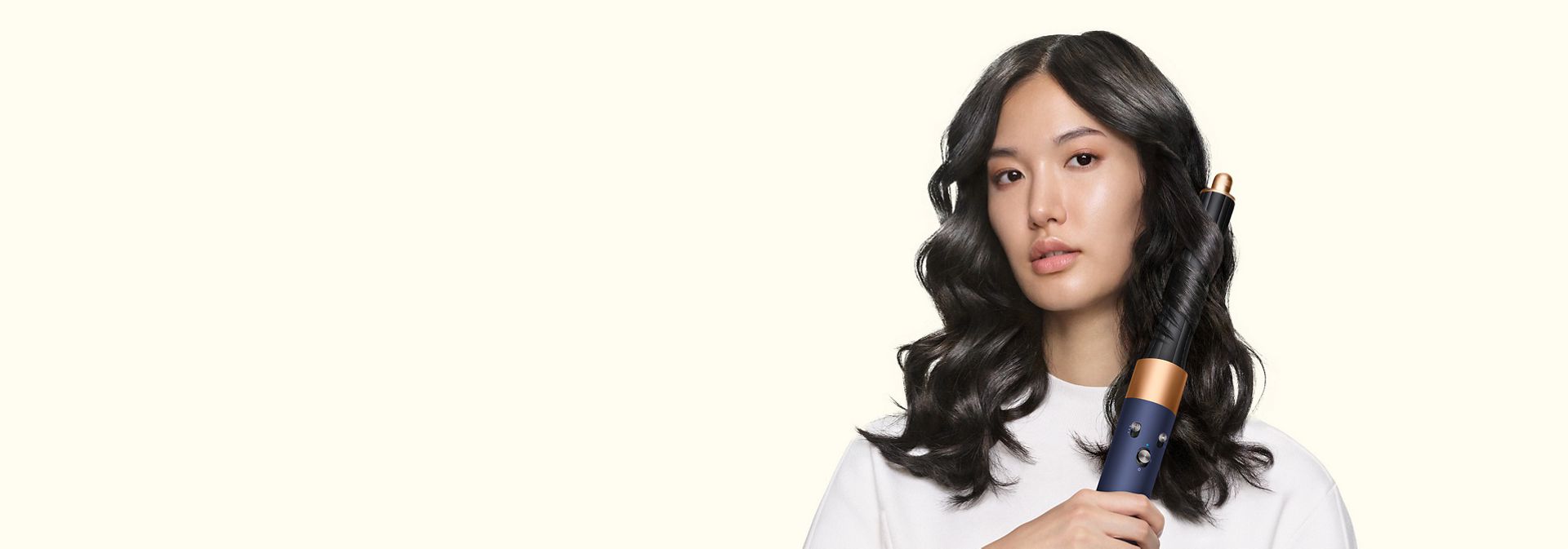 Model curls her hair using the Dyson Airwrap Origin multi-styler and dryer.