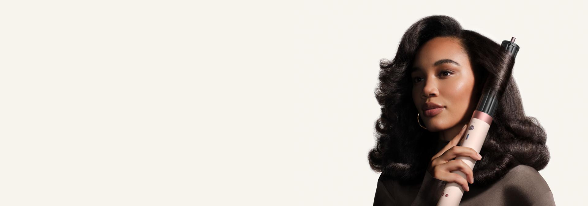 Model curls her hair with the Dyson 40mm Co-anda2x curling barrel.