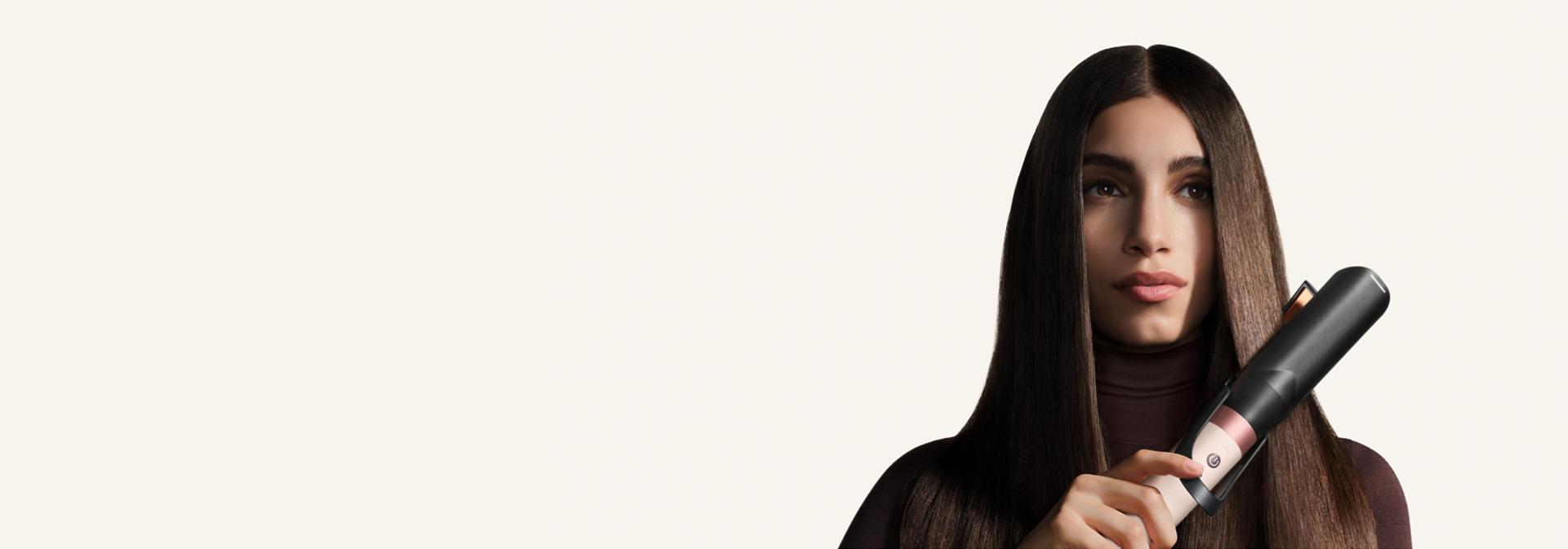Model straightens her hair with the Dyson Air straightener 2x attachment.