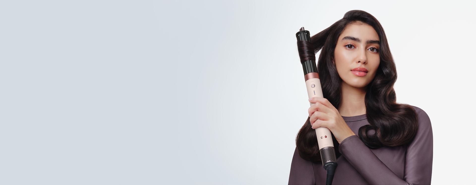Model curls her hair with the Dyson Airwrap Co-anda2x multi-styler and dryer.