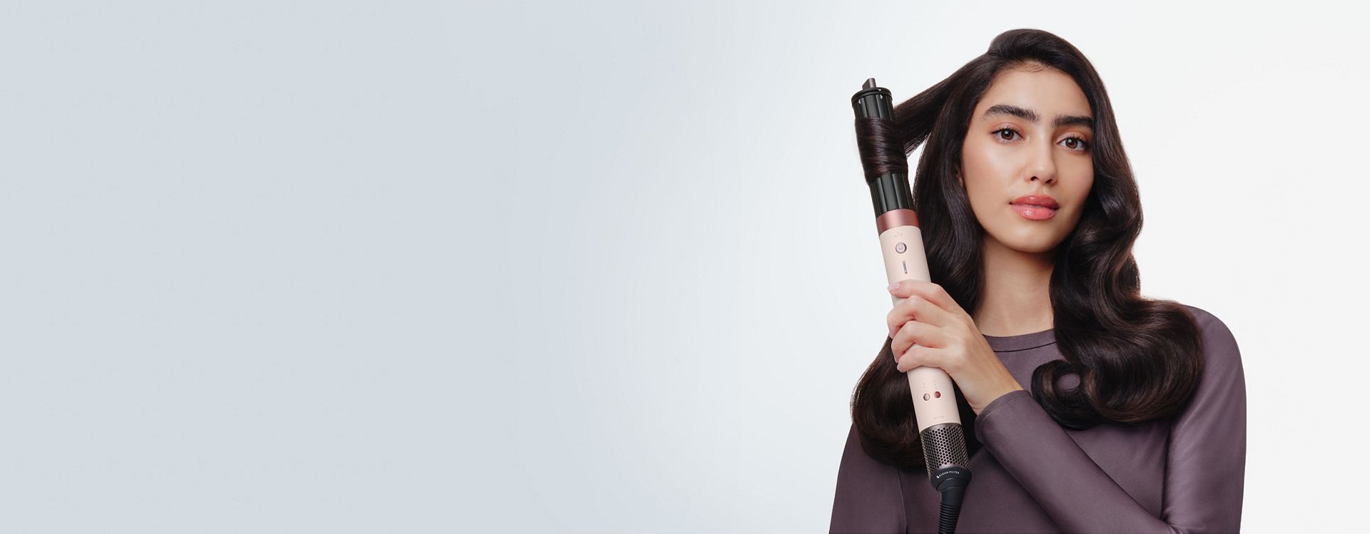 Model curls her hair with the Dyson Airwrap Co-anda2x multi-styler and dryer.
