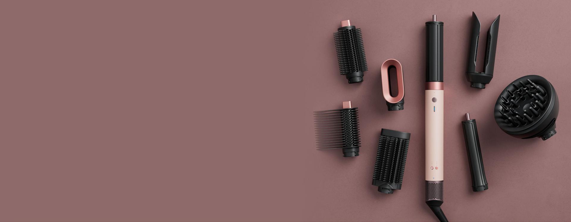 Dyson Airwrap Co-anda2x multi-styler and dryer surrounded by attachments.
