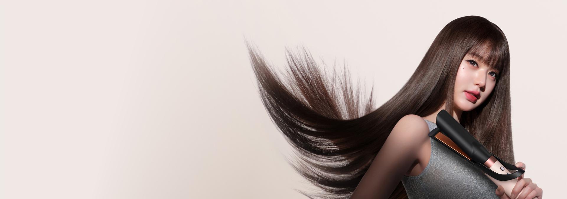 Model straightens her hair with the Dyson Air straightener 2x attachment.