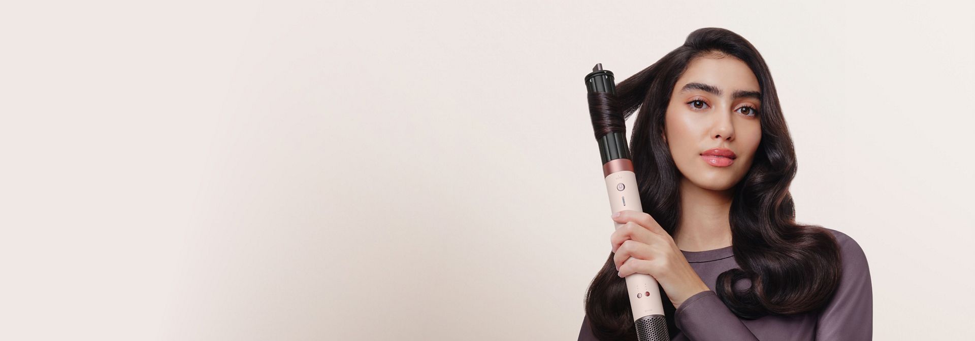 Model curls her hair with the Dyson 40mm Co-anda2x curling barrel.