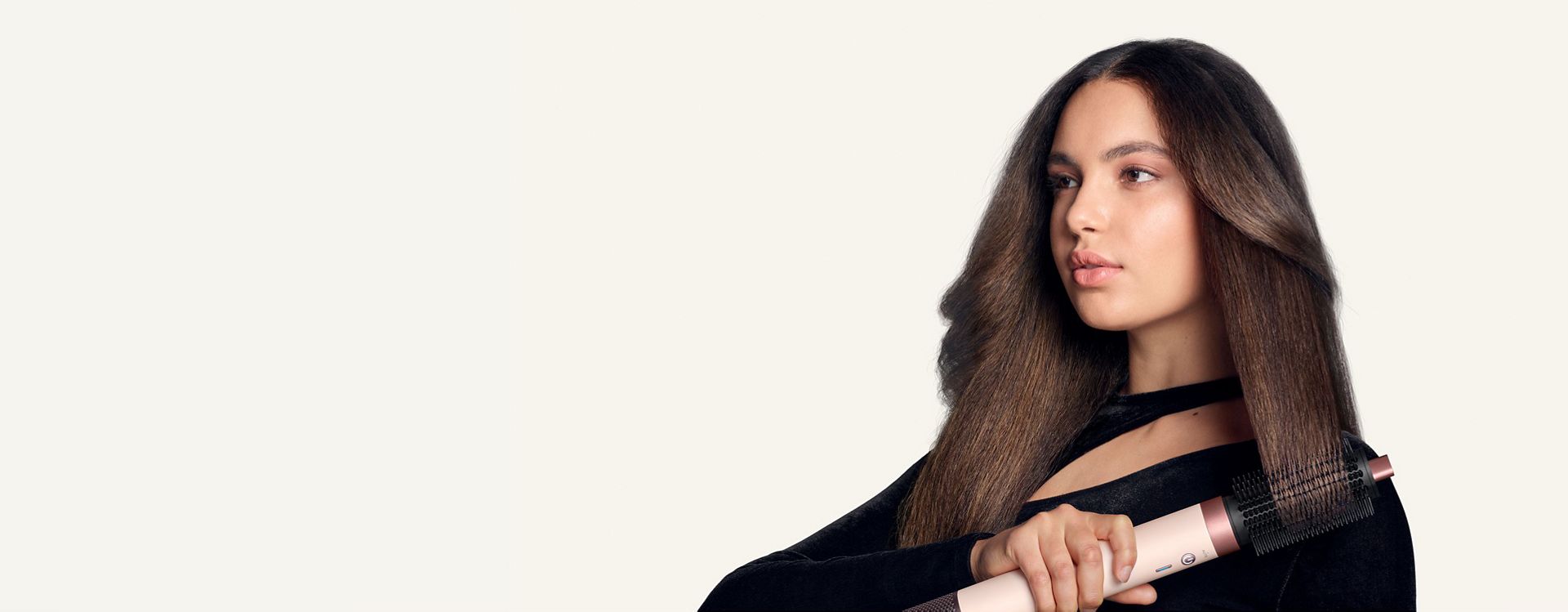 Model styles her hair with the Dyson Airwrap Co-anda2x Large round volumising brush 2x.