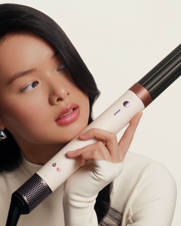Dyson Airwap Co-anda 2x multi-styler and dryer being held by a model