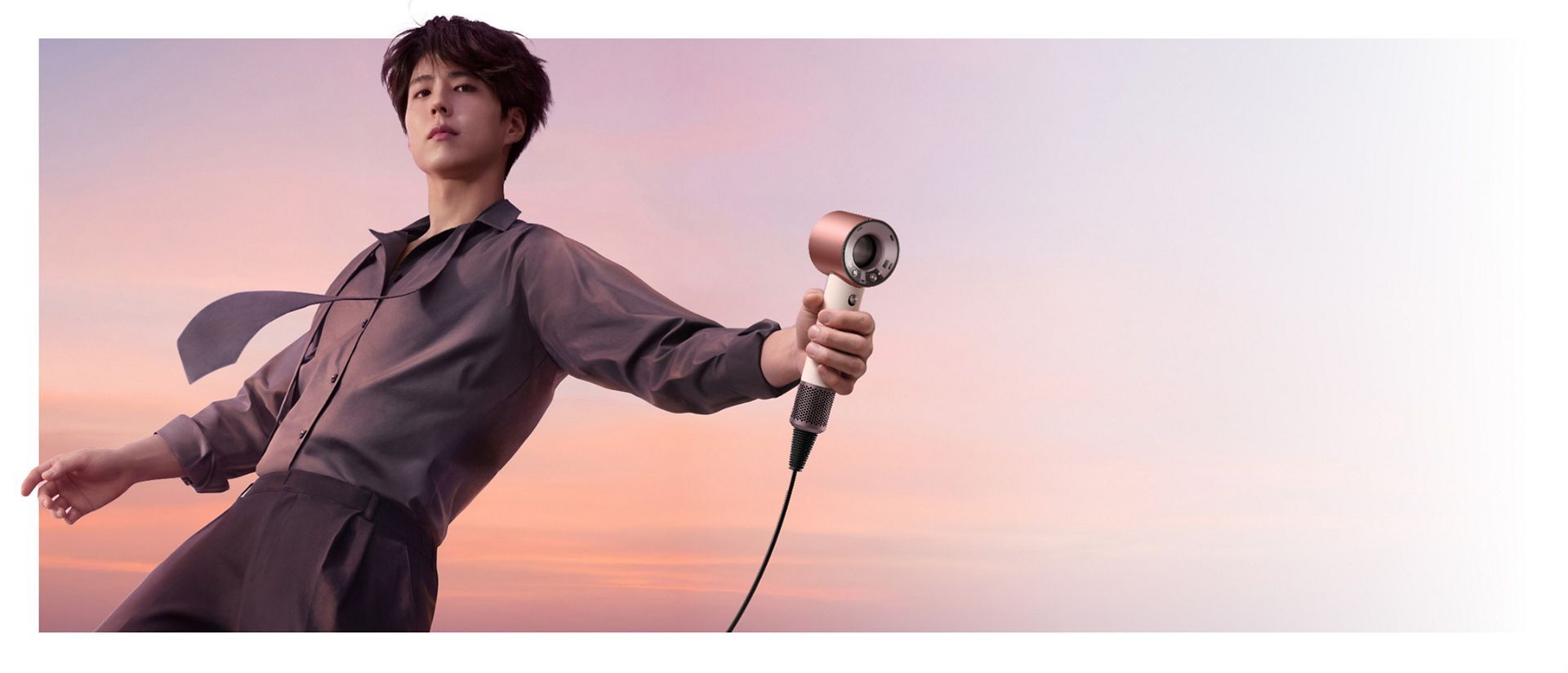 Model holding the Dyson Supersonic Travel hair dryer.