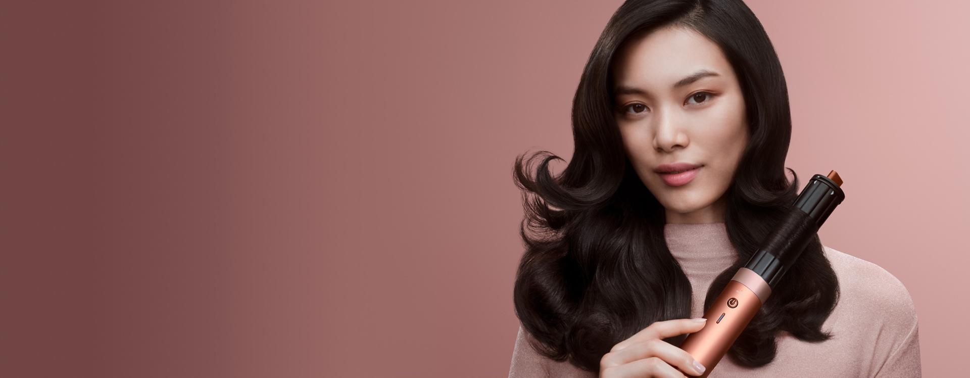 Modelka o ciemnych włosach tworzy loki za pomocą najnowszej suszarko-lokówki Dyson Airwrap Co-anda2x.