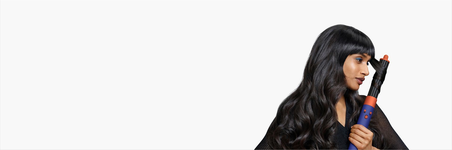 A model uses the Dyson Airwrap i.d. multi-styler and dryer with the 40mm long barrel to style their hair.