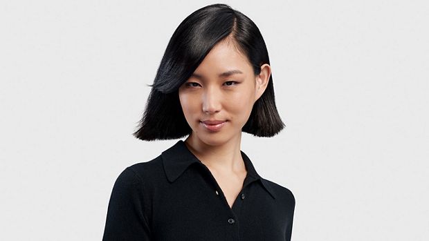 A model with medium length black hair styled into a short sleek bob.
