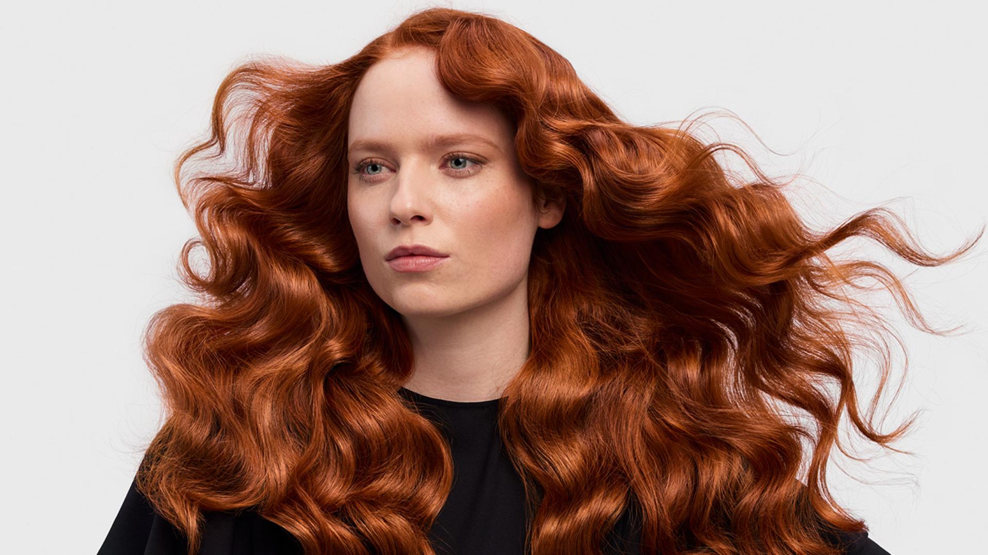 A redhead model with her long hair in a retro waves style.