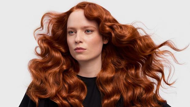 A redhead model with her long hair in a retro waves style.