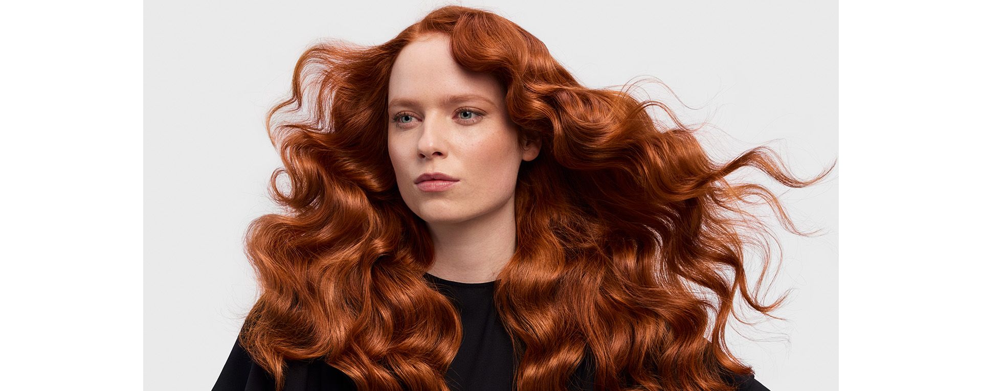 A redhead model with her long hair in a retro waves style.