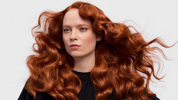 A redhead model with her long hair in a retro waves style.