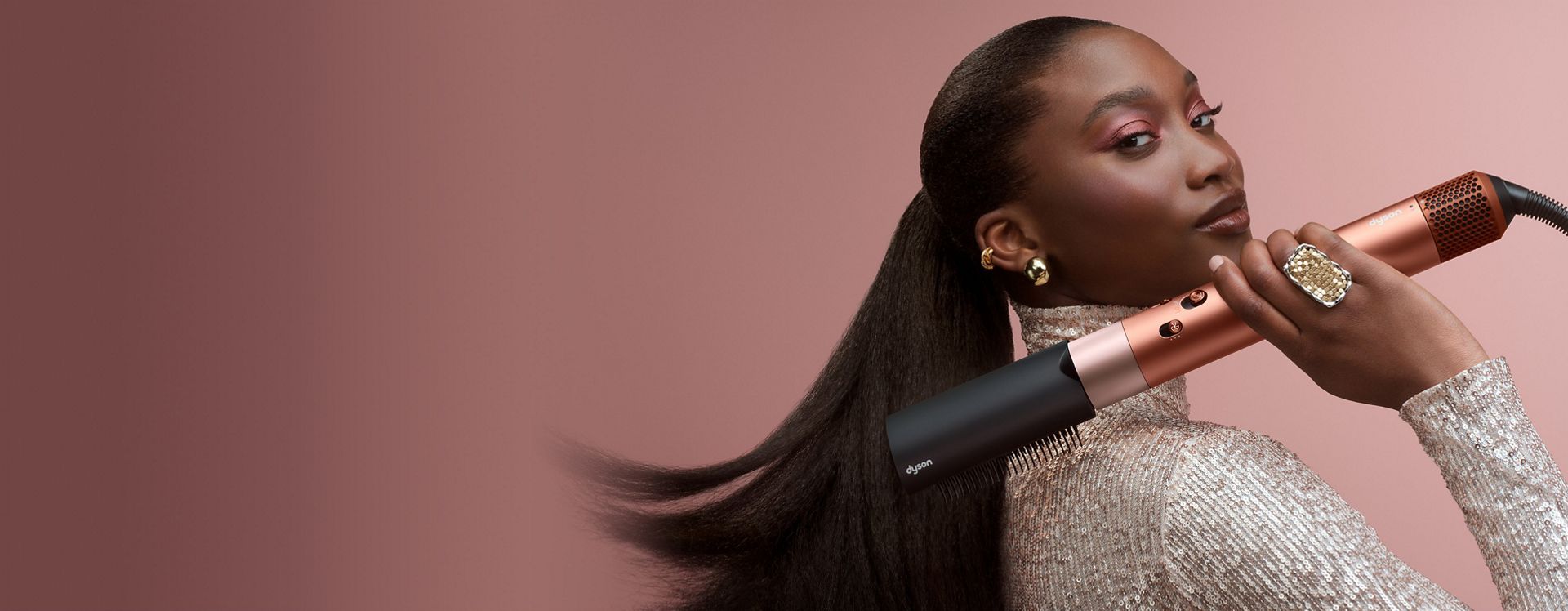 Egy modell a Dyson Airwrap ID multifunkciós hajformázó-szárítóval fésüli a haját.