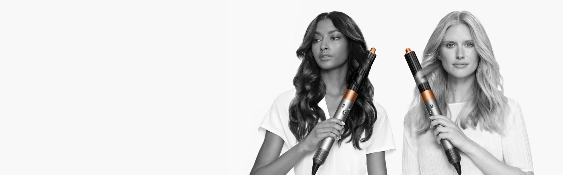 Dve modelky s rôznymi typmi vlasov si upravujú vlasy pomocou multistylera a sušiča vlasov Dyson Airwrap.