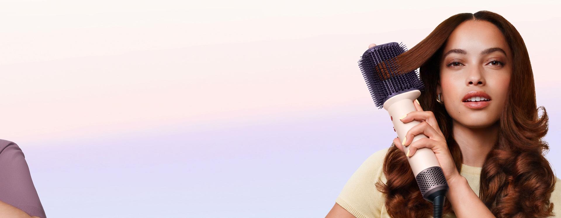 Model styles her hair with the Dyson Airsmooth styling brush.