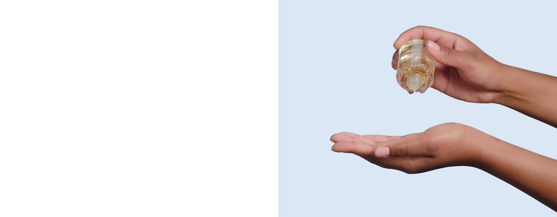 Dyson Omega hydrating hair oil is dispensed into the palm of a hand.