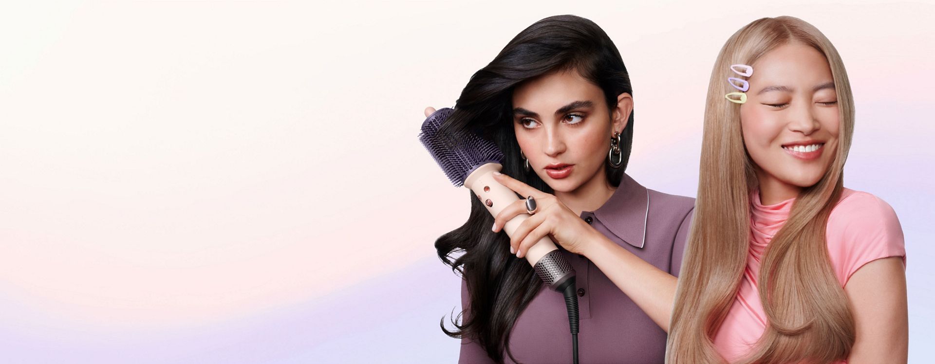 Pair of models style their hair with the Dyson Airsmooth styling brush and show off their smoothed hair.